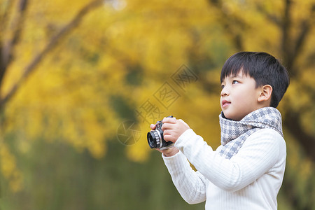 相机快门遥控器秋季儿童银杏树下拿相机拍照背景