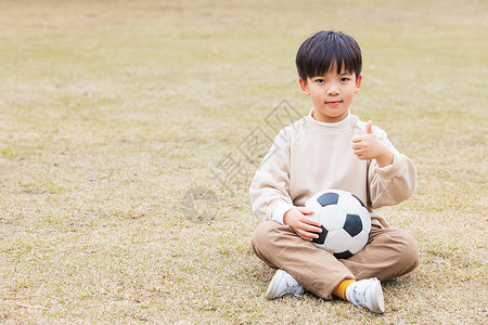 秋季小男孩公园草坪踢足球点赞图片