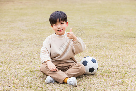 金色大拇指秋季小男孩公园草坪踢足球点赞背景