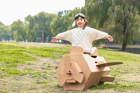 秋季小男孩抱着纸盒箱飞机嬉戏高清图片