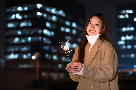 秋冬夜晚美女室外放烟花高清图片