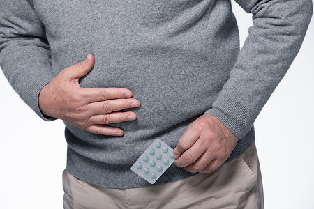 慢性胃炎拿着药片身体不适的老人背景