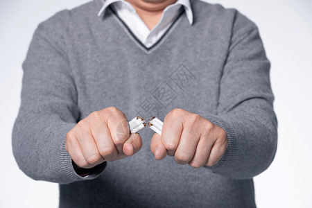 抽烟有害健康男性折断一把香烟手部特写背景