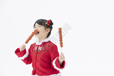小女孩轻轻品尝冰糖葫芦背景图片