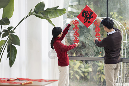 迎新年春节海报青年夫妻客厅贴春联迎新年背景