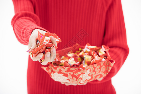 穿着红色毛衣的手抓起一把糖果背景图片