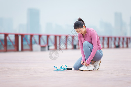 项目准备准备跳绳的女性在系鞋带背景