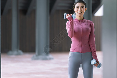 女性在户外用哑铃健身高清图片