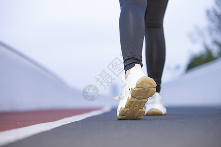 活动筋骨在跑道上准备起跑的女性脚部特写背景