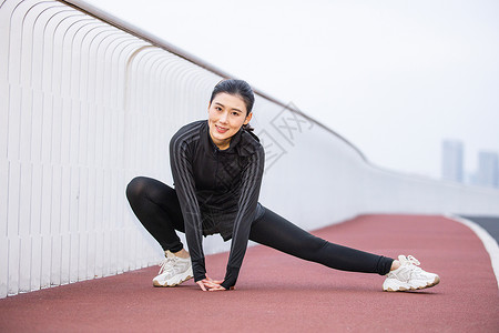 女性在跑道上做热身运动图片