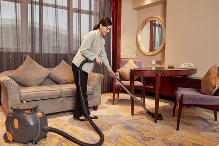酒店服务人员使用吸尘器清洁地毯高清图片