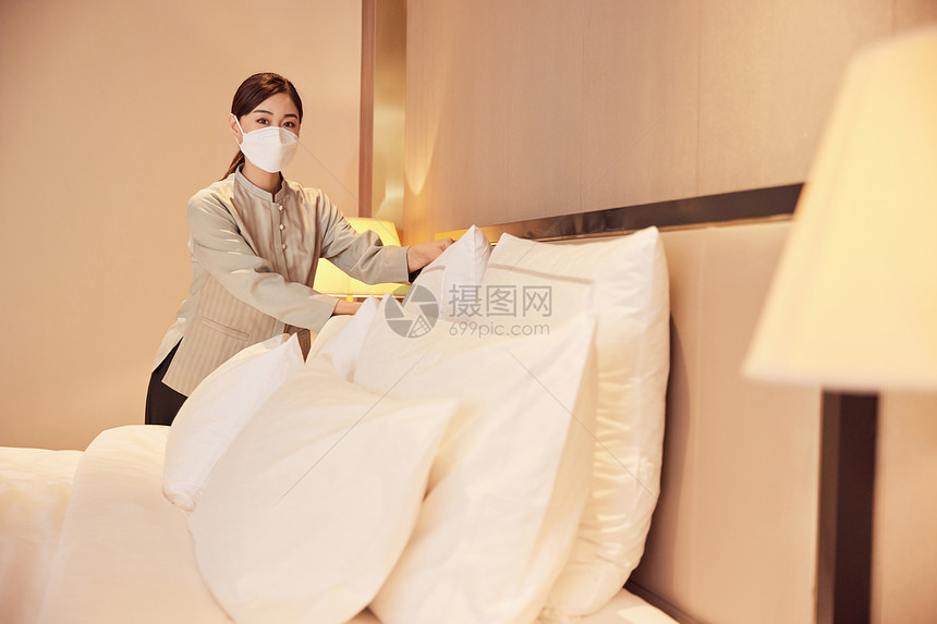 佩戴口罩酒店服务保洁员整理床铺图片