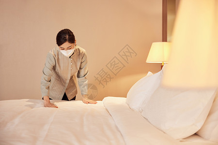归纳床铺佩戴口罩酒店服务保洁员整理床铺背景