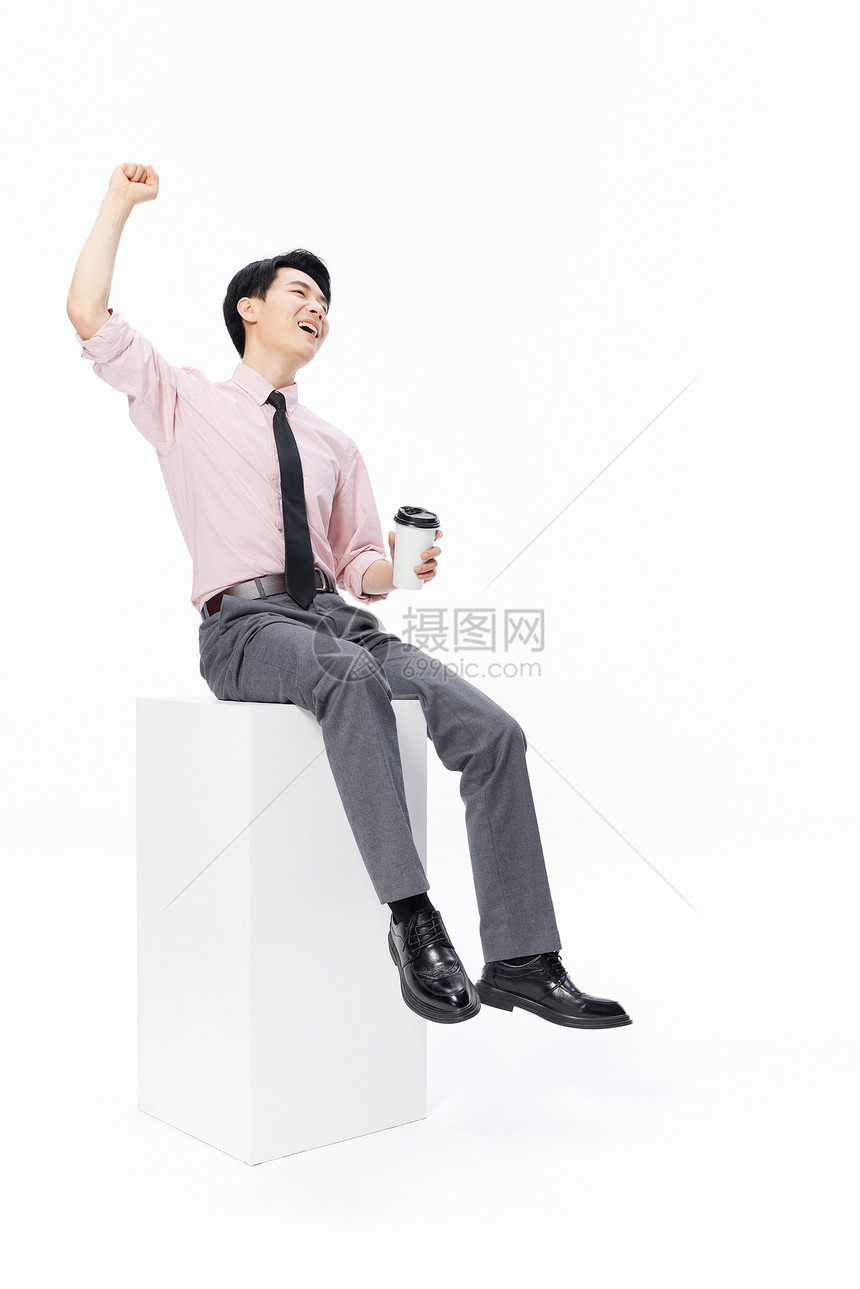 商务男士手拿咖啡杯欢呼庆祝图片