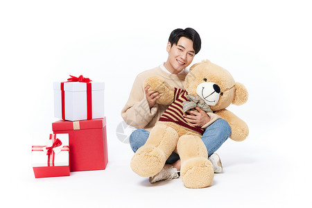 礼物熊阳光男生抱着毛绒玩具熊背景
