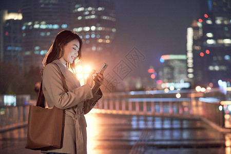 深夜下班深夜加班的都市女性使用手机打车背景