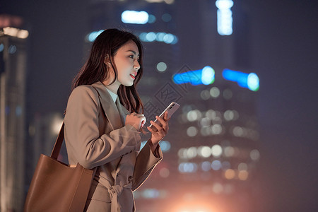 深夜下班深夜加班的都市女性使用手机打车背景