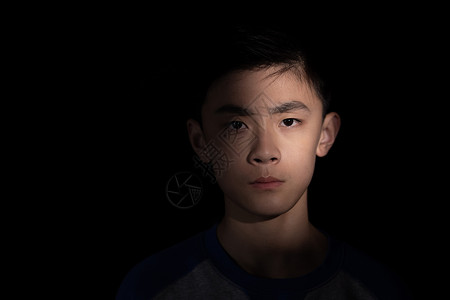 遭受虐待黑暗里的青少年男孩背景图片