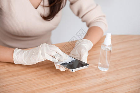 女性居家办公清洁手机消毒高清图片