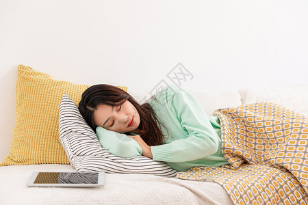冬季单身女性独居躺在沙发上睡觉高清图片