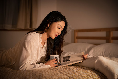 夜晚女性卧室里熬夜阅读看书图片