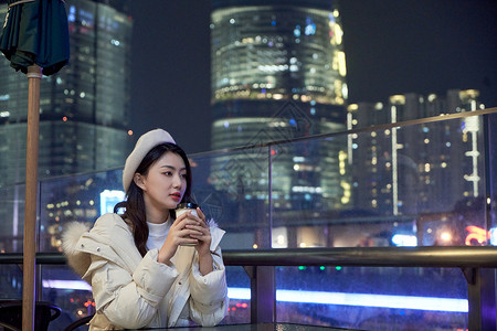 夜晚坐在咖啡厅休息的都市女孩图片