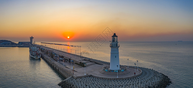 海岸灯塔素材海上日出时的青岛情人坝和灯塔背景