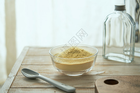 健身食品窗边木桌上的蛋白粉背景