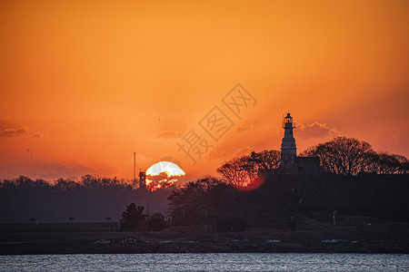 红色日出日出时的小青岛灯塔剪影背景
