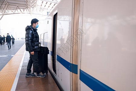 冬天上车拉着行李箱准备上高铁的男性背景