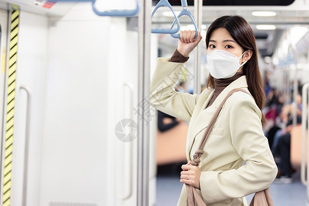 下班回家的女性戴口罩乘坐地铁背景图片