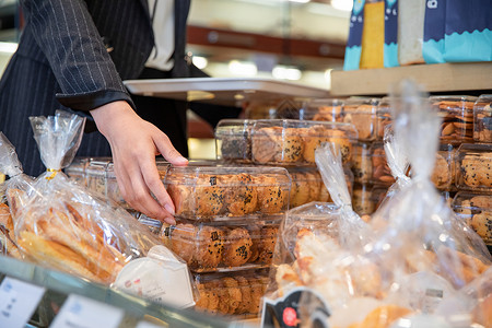 面包圈面包店穿着工作装的女性在面包店选购商品背景