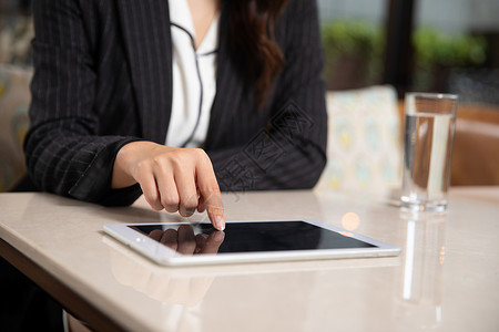商务休息下午茶身穿商务装的女性使用平板电脑点餐背景