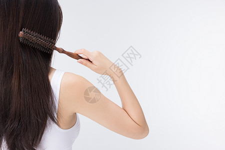 梳头发美女女性使用梳子梳头发背影背景