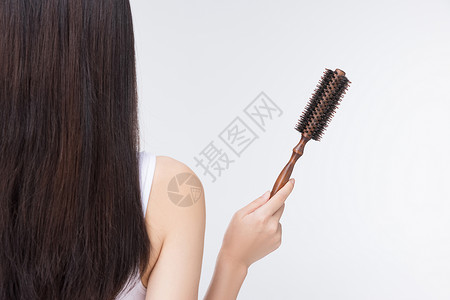 梳头发美女女性使用梳子梳头发背影背景