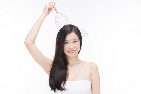 美发头部素材女性使用按摩器按摩头部背景