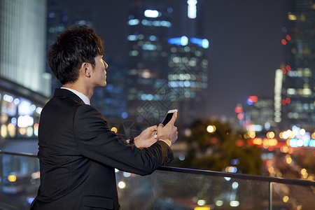 城市迷茫商务男士夜晚使用手机背景