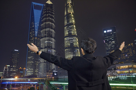 夜晚都市男青年拥抱城市背影图片