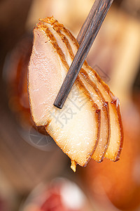 筷子夹起来的腊肉筷子夹起腊肉背景