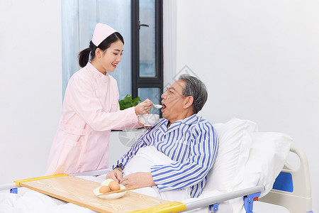 护士给手脚不便的老人喂食照顾高清图片