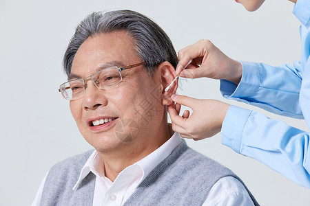 老人耳朵使用棉签为男性老人采耳背景