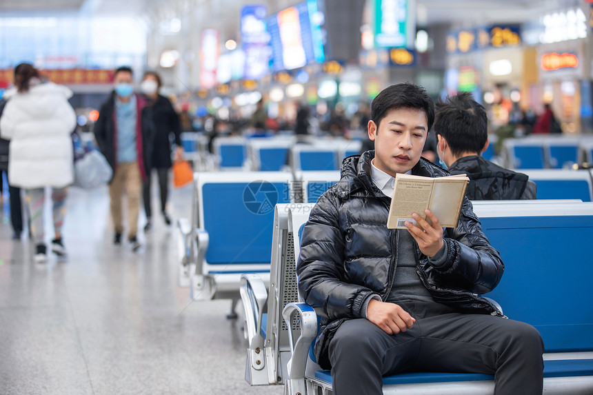 坐在候车厅看书的男性图片