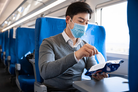 在列车上使用消毒湿巾的男性图片