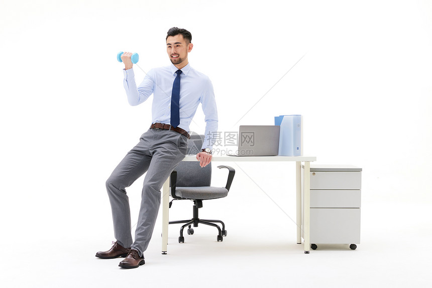男性在办公室靠着桌子举哑铃图片