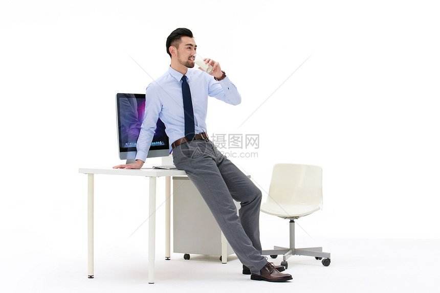 男性靠在桌子上喝牛奶图片