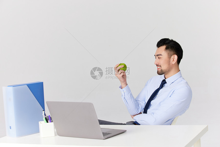喜欢吃苹果的职场男性图片