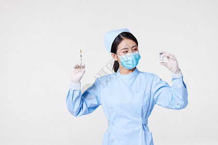 戴口罩的护士手拿注射器和疫苗图片