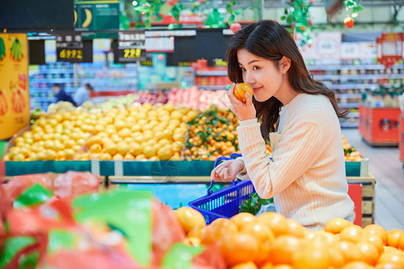 年轻女性超市挑选购买水果背景图片