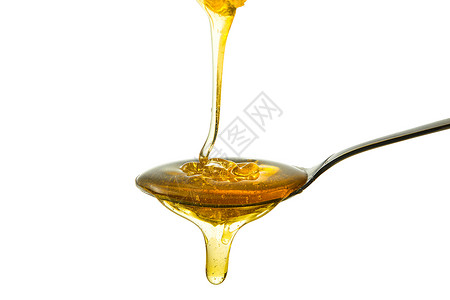 蜂蜜从勺子上滴下高清图片
