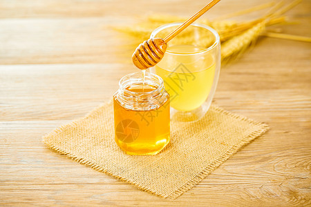 新鲜蜂蜜木桌上的蜂蜜和蜂蜜水背景